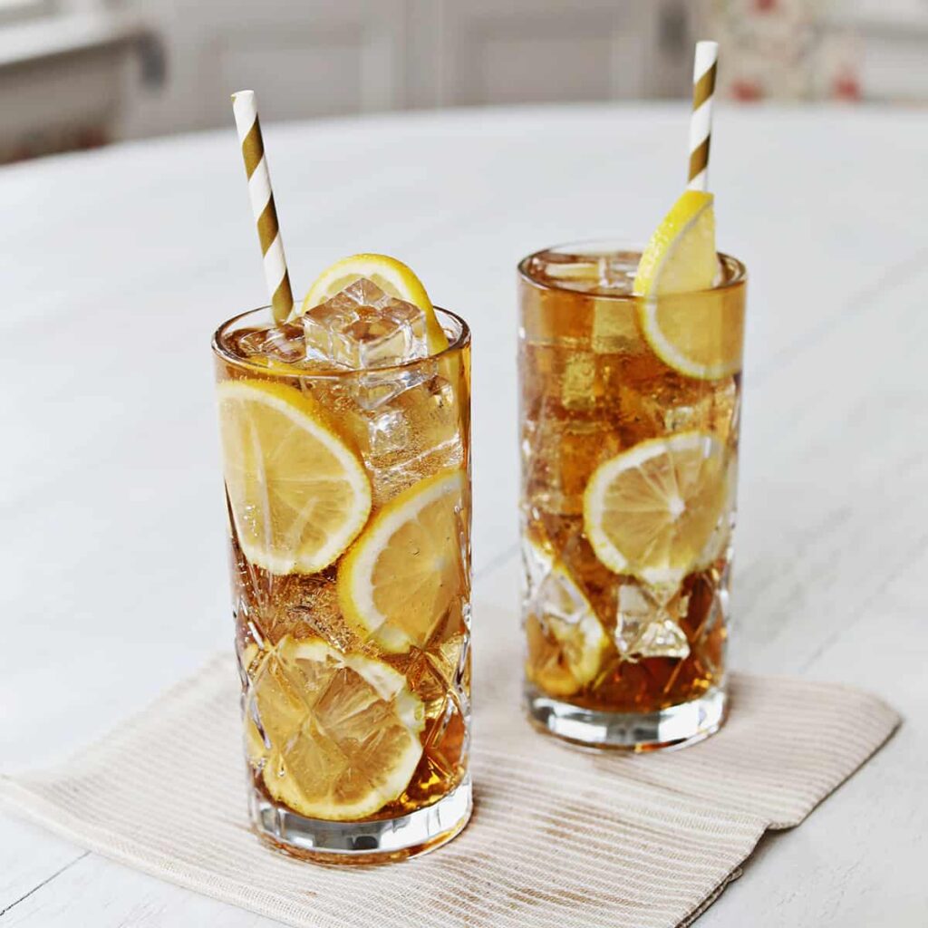 Long Island Iced Tea cocktail with lemon wedge