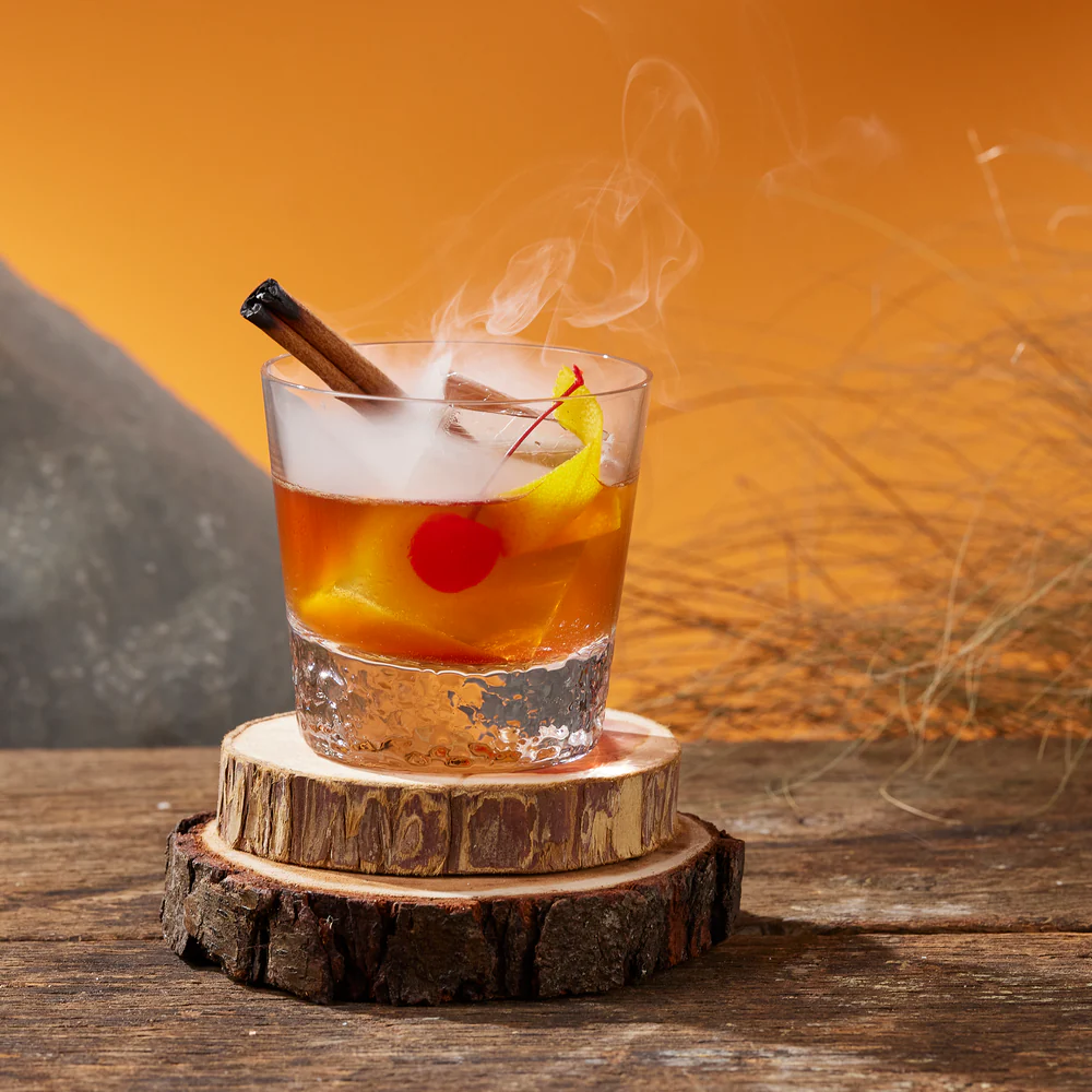 Old Fashioned cocktail with orange peel and ice cube