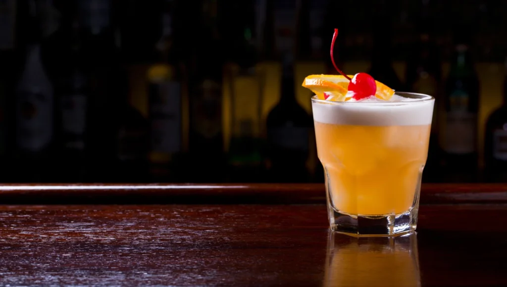 Classic Whiskey Sour cocktail in rocks glass with lemon garnish