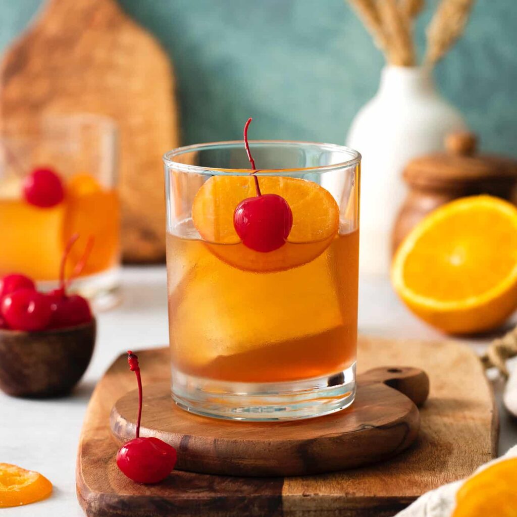 Old Fashioned cocktail with orange peel and ice cube