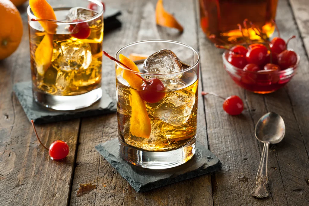 Old Fashioned cocktail with orange peel and ice cube