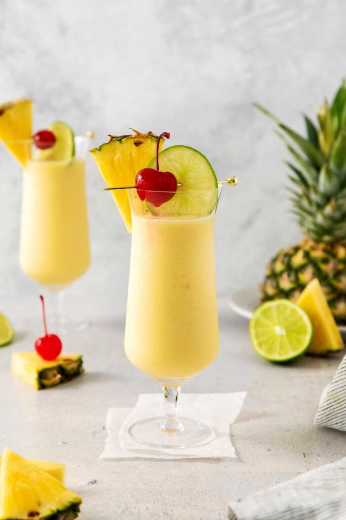 Piña Colada cocktail in hurricane glass with pineapple garnish
