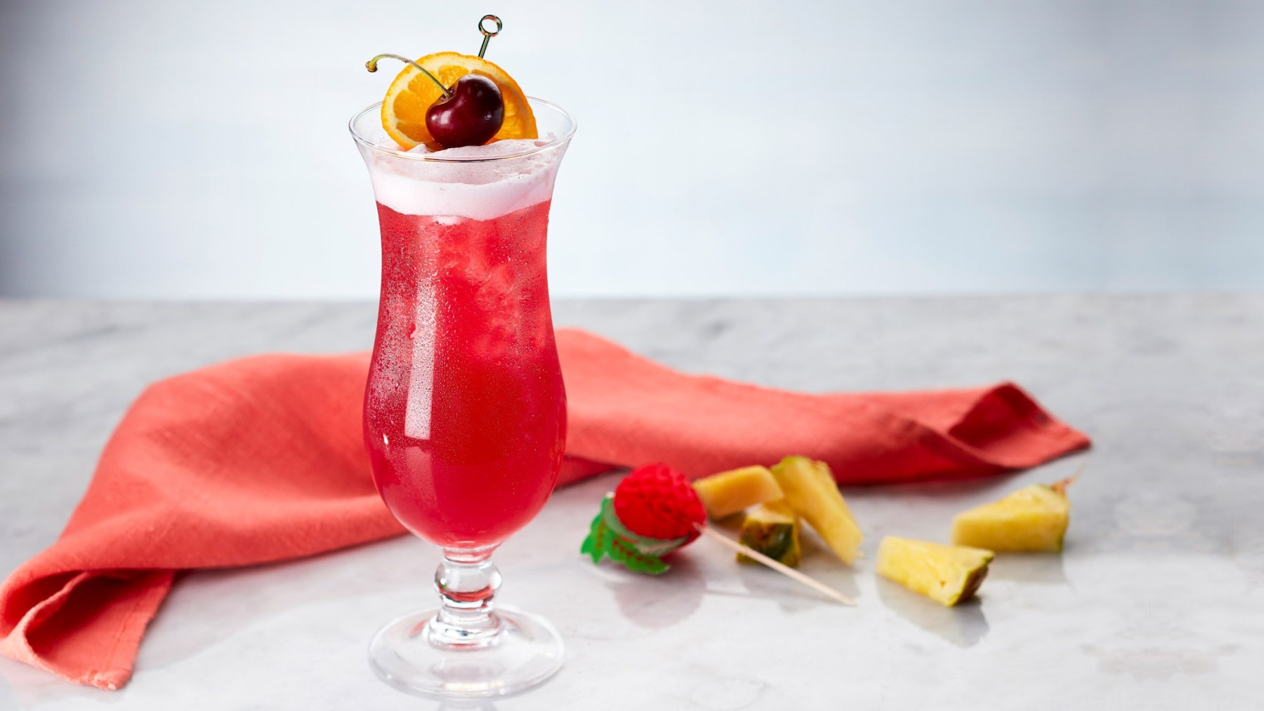 Singapore Sling cocktail with cherry and pineapple garnish